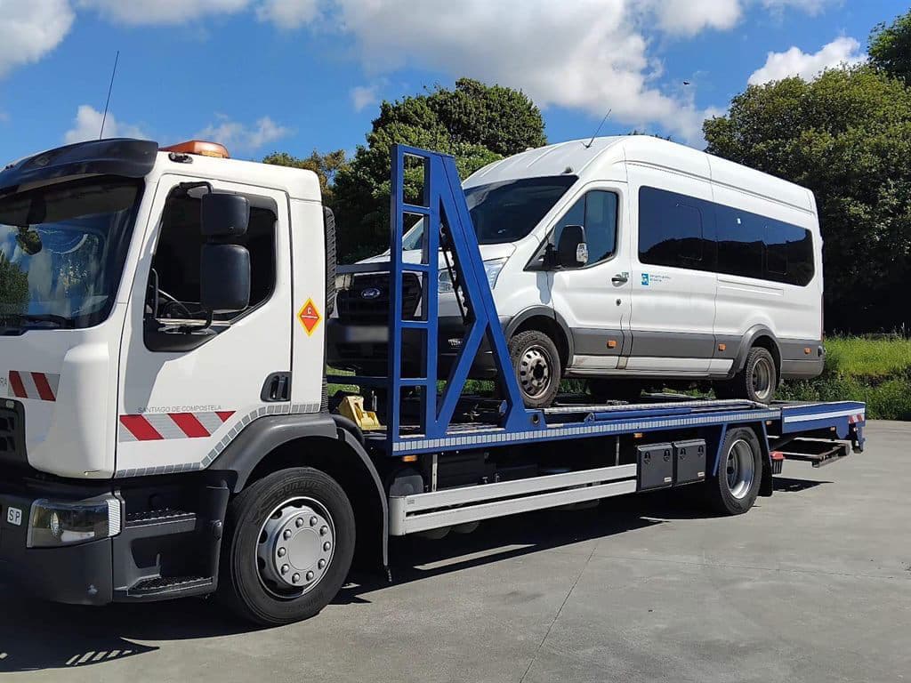 Grúa 24 horas de Menfer con un microbús cargado en la plataforma en Santiago de Compostela