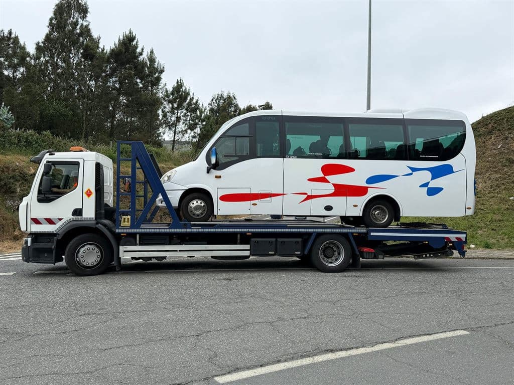 Grúa de Menfer trasladando un microbús por una carretera de Santiago de Compostela
